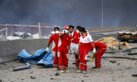 Une photo fournie par le Croissant-Rouge iranien le 27 avril 2025 montre des secouristes évacuant une victime du site de l'explosion survenue la veille dans le port de Shahid Rajaï, près de Bandar Abbas, dans la province iranienne de Hormozgan (sud) ( Iranian Red Crescent / - )