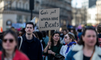 Une manifestante brandit une pancarte proclamant "Grils just wanna have... rights" ("Les filles veulent juste avoir des droits"), lors de la manifestation pour la journée internationale des droits des femmes, le 8 mars 2025 à Paris ( AFP / Martin BUREAU )