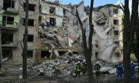 Des équipes de secours devant un immeuble résidentiel touché par une frappe russe à Kiev, le 23 juin 2025 en Ukraine ( AFP / Genya SAVILOV )