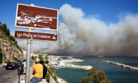 Le nuage de fumée d'un incendie visible depuis la plage des Corbières à Marseille, le 8 juillet 2025 ( AFP / Clement MAHOUDEAU )