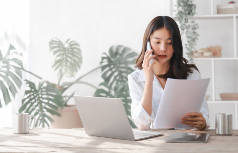Une femme en train de passer un appel téléphonique pour la gestion de son épargne (Crédits: Adobe Stock)