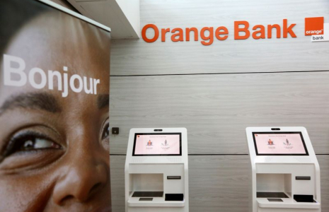 Des distributeurs automatiques sont visibles dans une banque de l'opérateur mobile français Orange à Abidjan